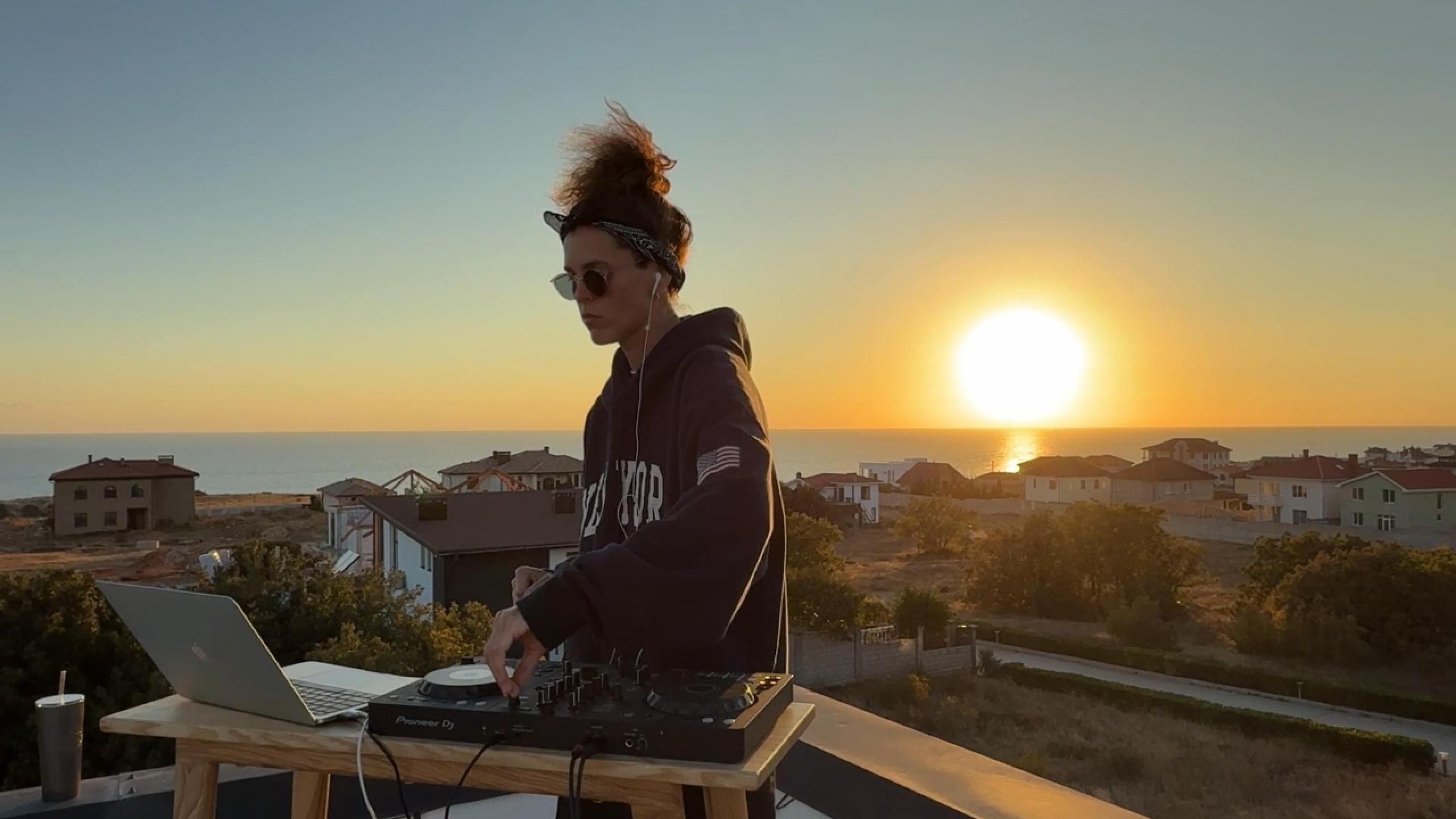 DJ Bloody Tomato performing a rooftop electronic mix at sunset